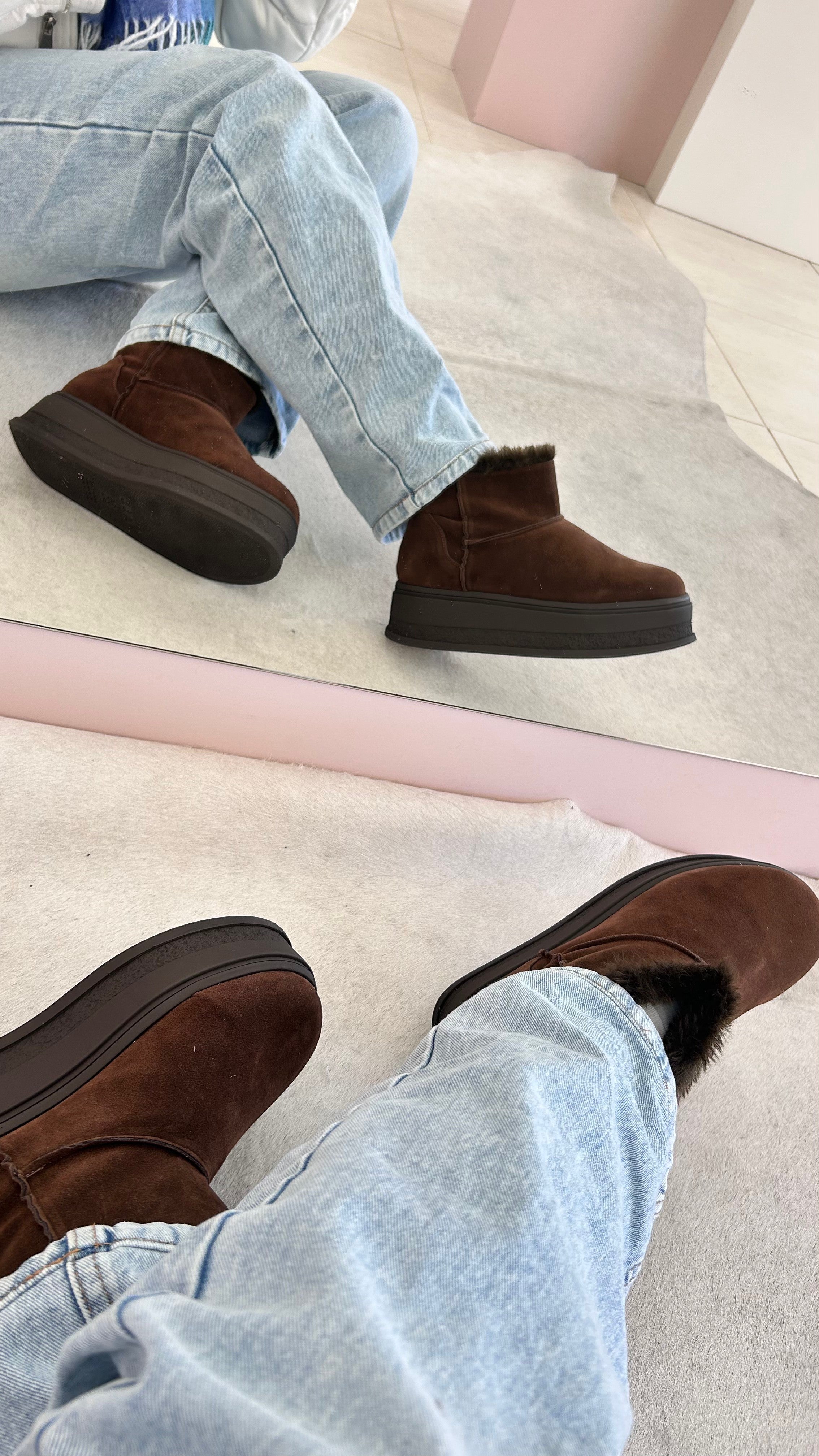 Bota Alaska Beyou Shoes marrom em camurça sintética com sola alta e forro interno de pelos, vista no espelho.