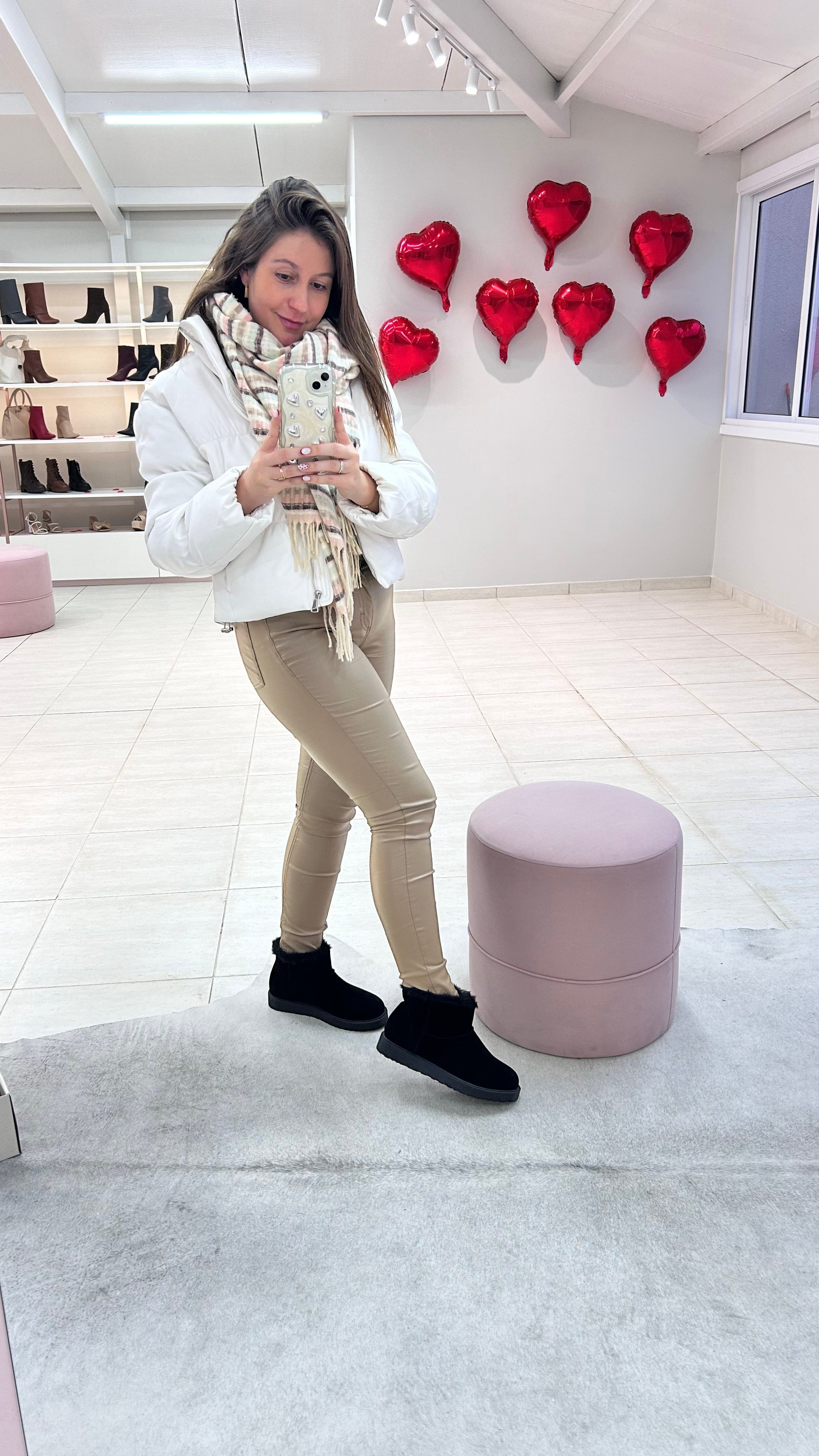 Mulher usando bota Alaska preta de camurça sintética com forro de pelinho da Beyou Shoes em ambiente de loja