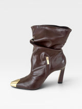 Bota Beyou Shoes Bristol marrom em napa estilo slouch com cano franzido, salto de 10cm e biqueira em ouro light.