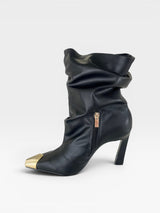 Bota Beyou Shoes Bristol preta em napa estilo slouch com cano franzido, salto de 10cm e biqueira em ouro light.