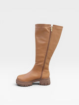Bota cano longo Beyou Shoes Cardiff na cor âmbar, feita em napa com solado tratorado e fechamento lateral por zíper.