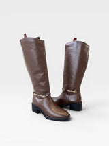 Bota cano longo Beyou Shoes marrom com detalhe de fivela dourada e salto baixo, design clássico e elegante.