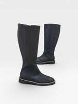 Bota cano longo Beyou Shoes preta em napa com detalhe de corrente dourada no solado rasteiro