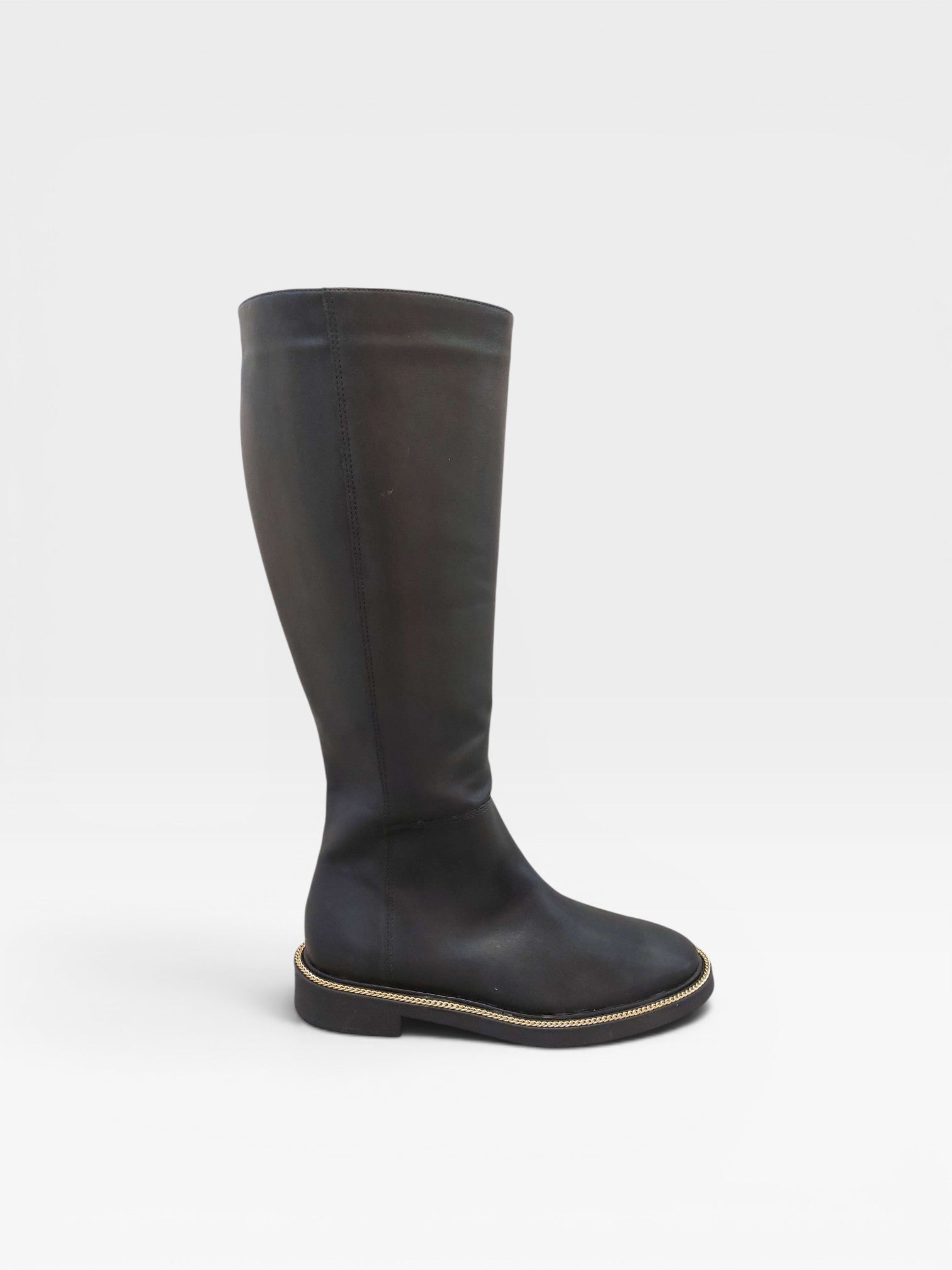 Bota cano longo preta Beyou Shoes em napa com solado flat e detalhe de corrente dourada na base
