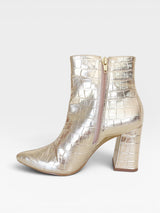 Bota Beyou Shoes Cartagena dourada com textura croco, salto bloco de 9 cm e fechamento lateral por zíper.
