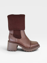Bota Beyou Shoes Dublin marrom em napa com cano em tricô, salto médio e solado tratorado moderno.