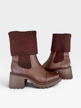 Bota Beyou Shoes Dublin marrom em napa com cano em tricô, solado tratorado e salto médio de 6 cm.