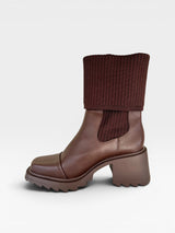 Bota Dublin Beyou Shoes marrom em napa com cano em tricô canelado, salto médio tratorado e bico quadrado.