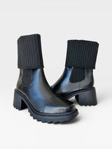 Bota Beyou Shoes Dublin preta em napa com cano em tricô, salto médio de 6 cm e solado tratorado moderno.
