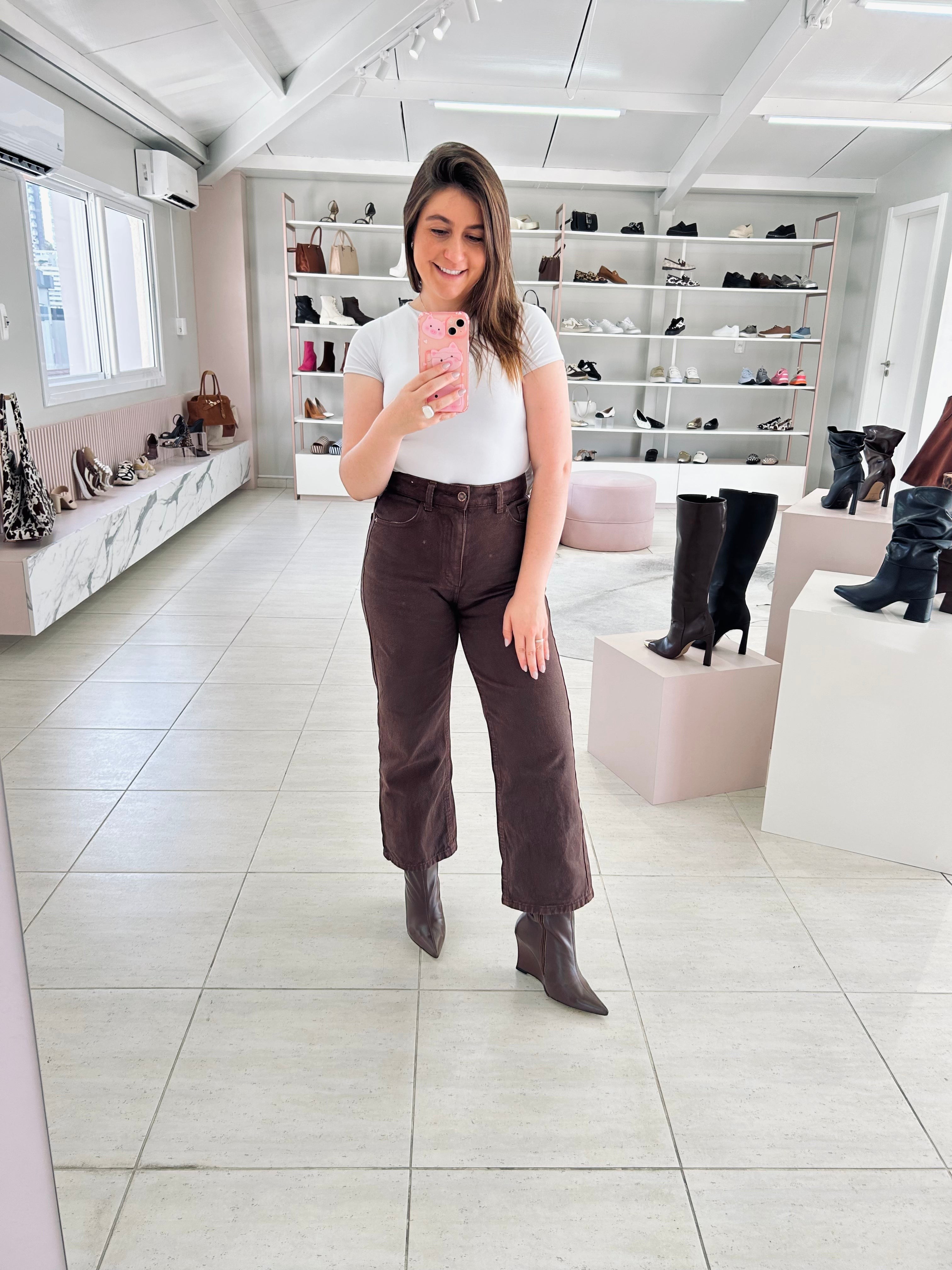 Mulher usando bota Manchester Beyou Shoes marrom de couro com salto anabela em loja de calçados
