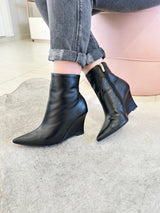 Bota Beyou Shoes Manchester preta em couro com salto anabela e bico fino, calçada com calça jeans cinza