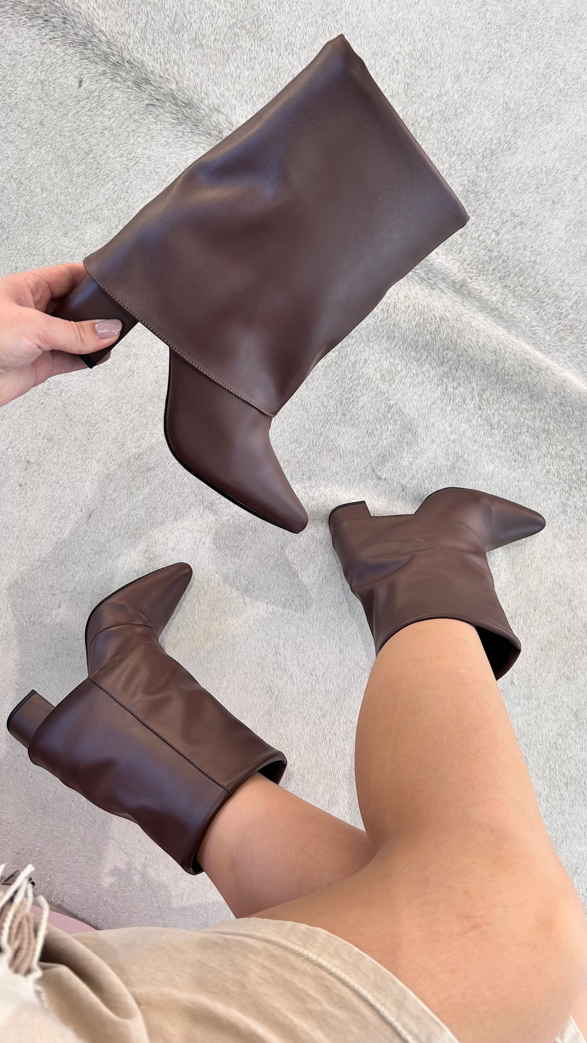 Bota Memphis Beyou Shoes marrom em napa com salto de 8,5 cm, exibida em mãos e calçada em fundo neutro.