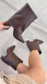 Bota Memphis Beyou Shoes marrom em napa com salto de 8,5 cm, exibida em mãos e calçada em fundo neutro.