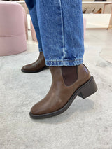 Bota Beyou Shoes Ohio marrom em napa destroyed com elástico lateral, usada com calça jeans em ambiente interno.