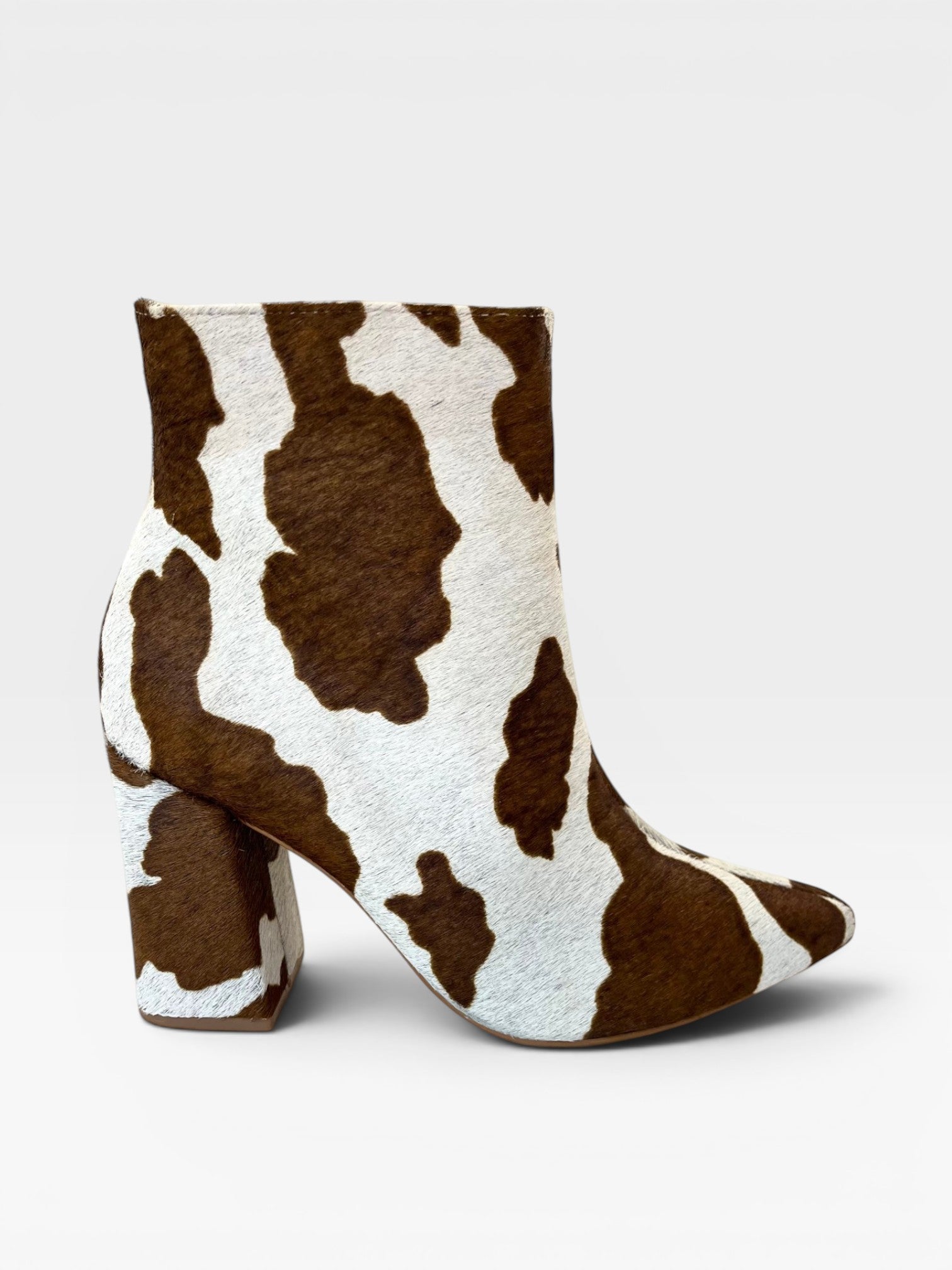 Bota Paris Beyou Shoes em couro com estampa animal print de vaquinha marrom e salto alto bloco