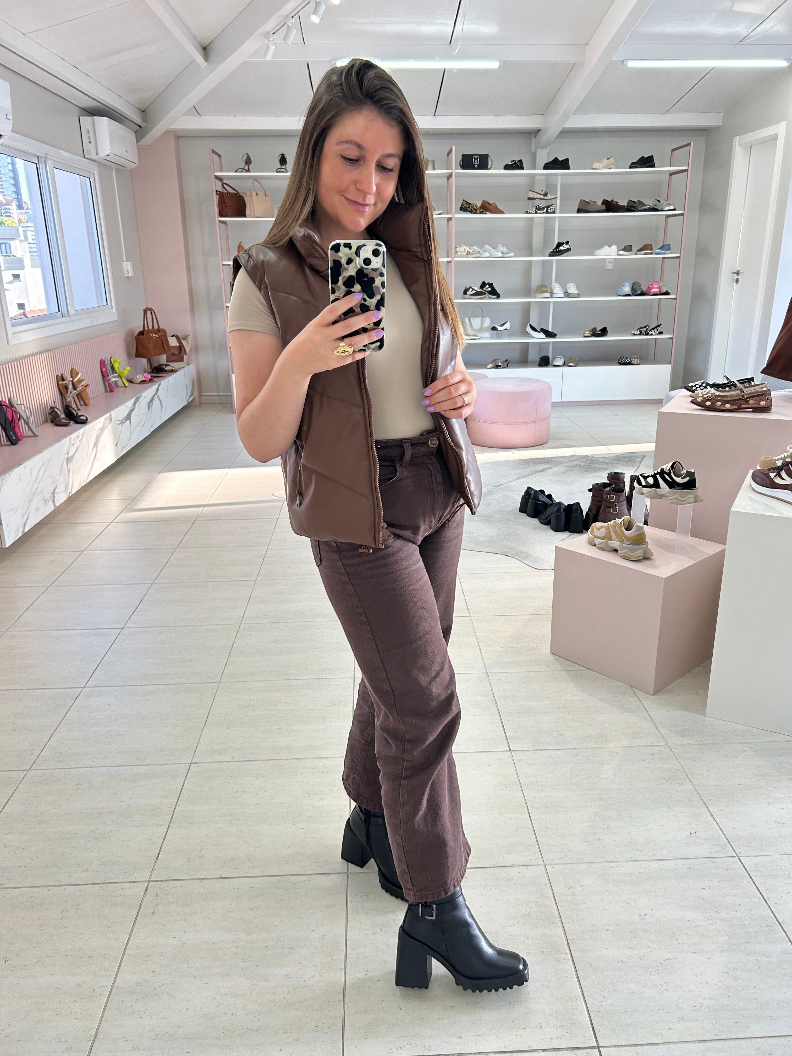 Mulher usando bota preta de couro Beyou Shoes com salto alto em loja de calçados com visual urbano e moderno