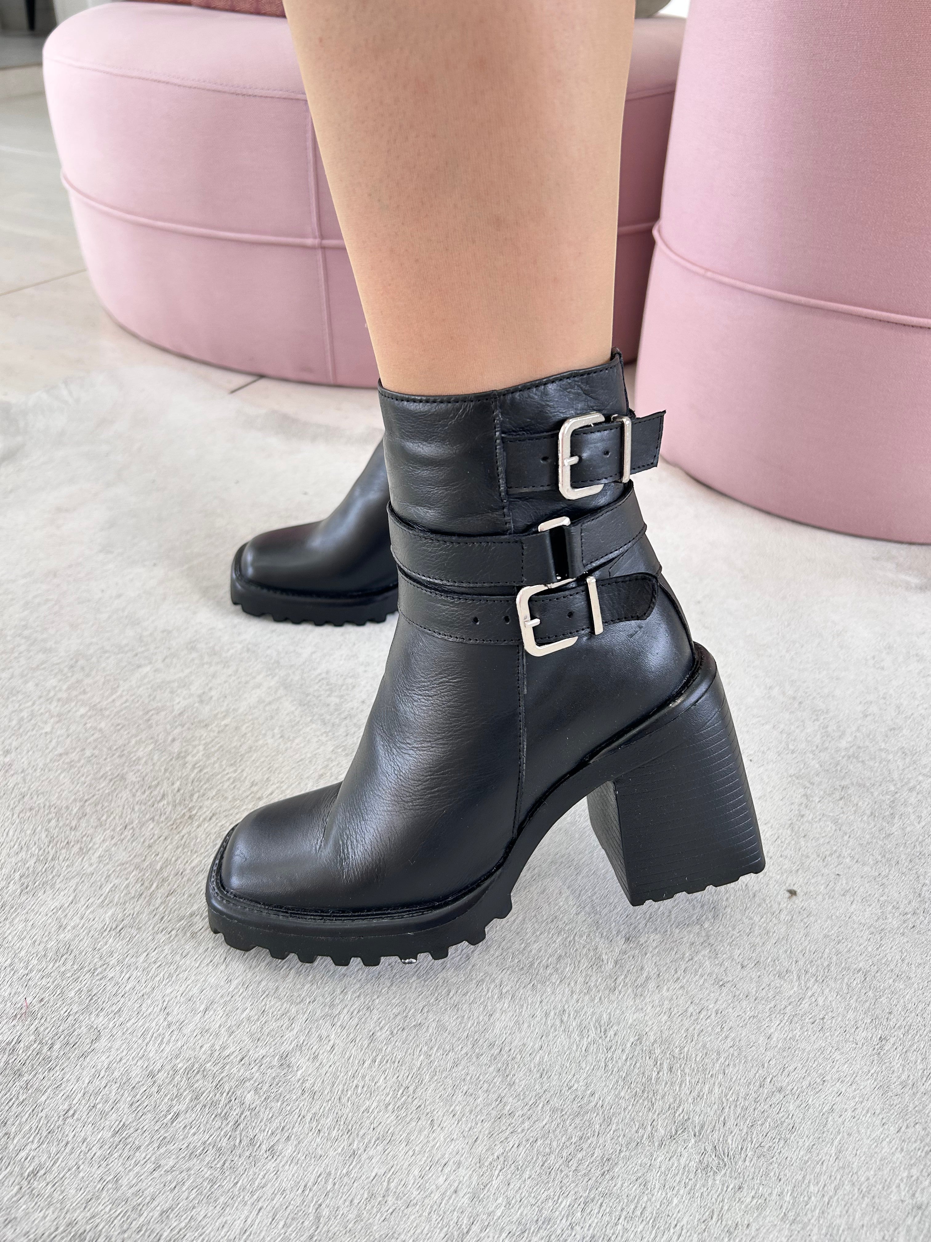 Bota Beyou Shoes Trento preta em couro com salto bloco de 10 cm, bico quadrado e tiras com fivelas prateadas no tornozelo