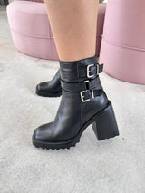 Bota Beyou Shoes Trento preta em couro com salto bloco de 10 cm, bico quadrado e tiras com fivelas prateadas no tornozelo