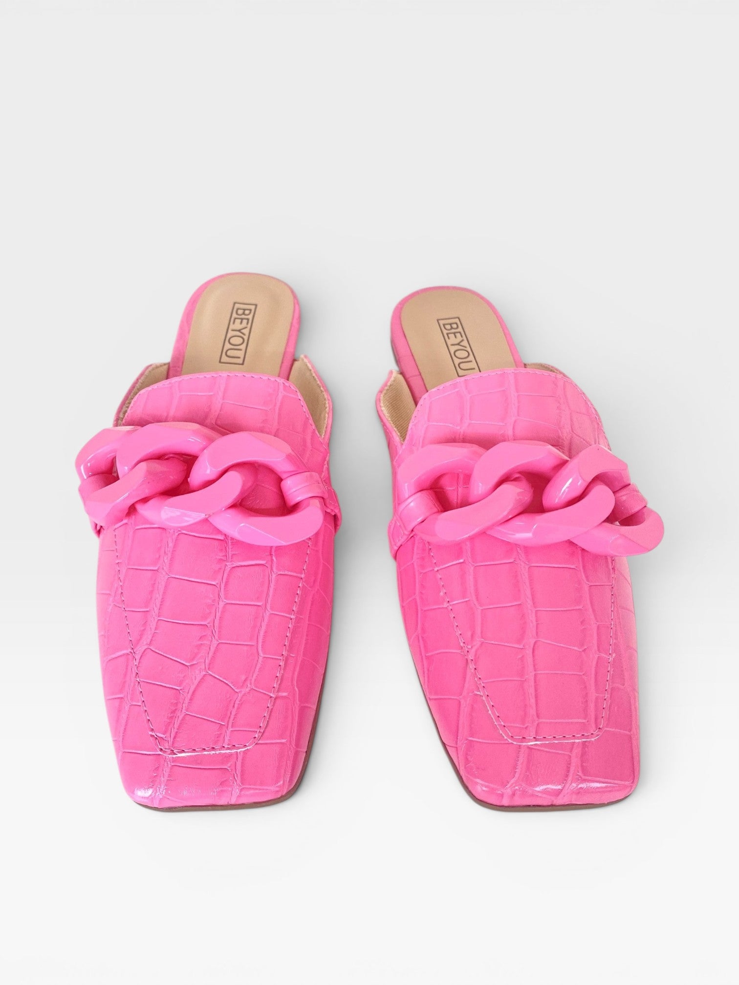 Mule Beyou Shoes Glasgow rosa chiclete em napa com textura croco, bico quadrado e detalhe de corrente no cabedal.
