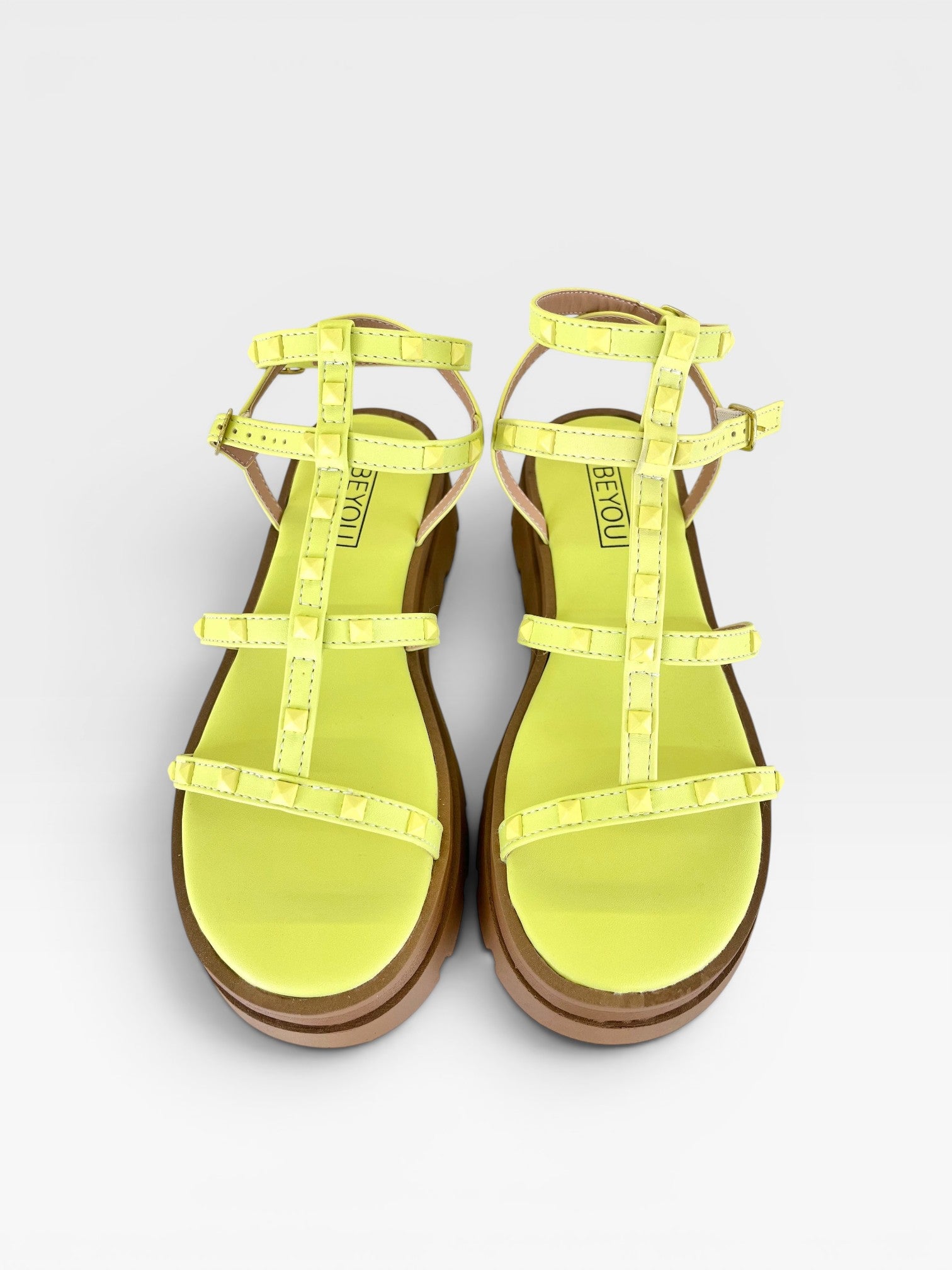 Papete Beyou Shoes Geórgia na cor limão siciliano, feita em napa com tiras cravejadas de tachas e solado tratorado.