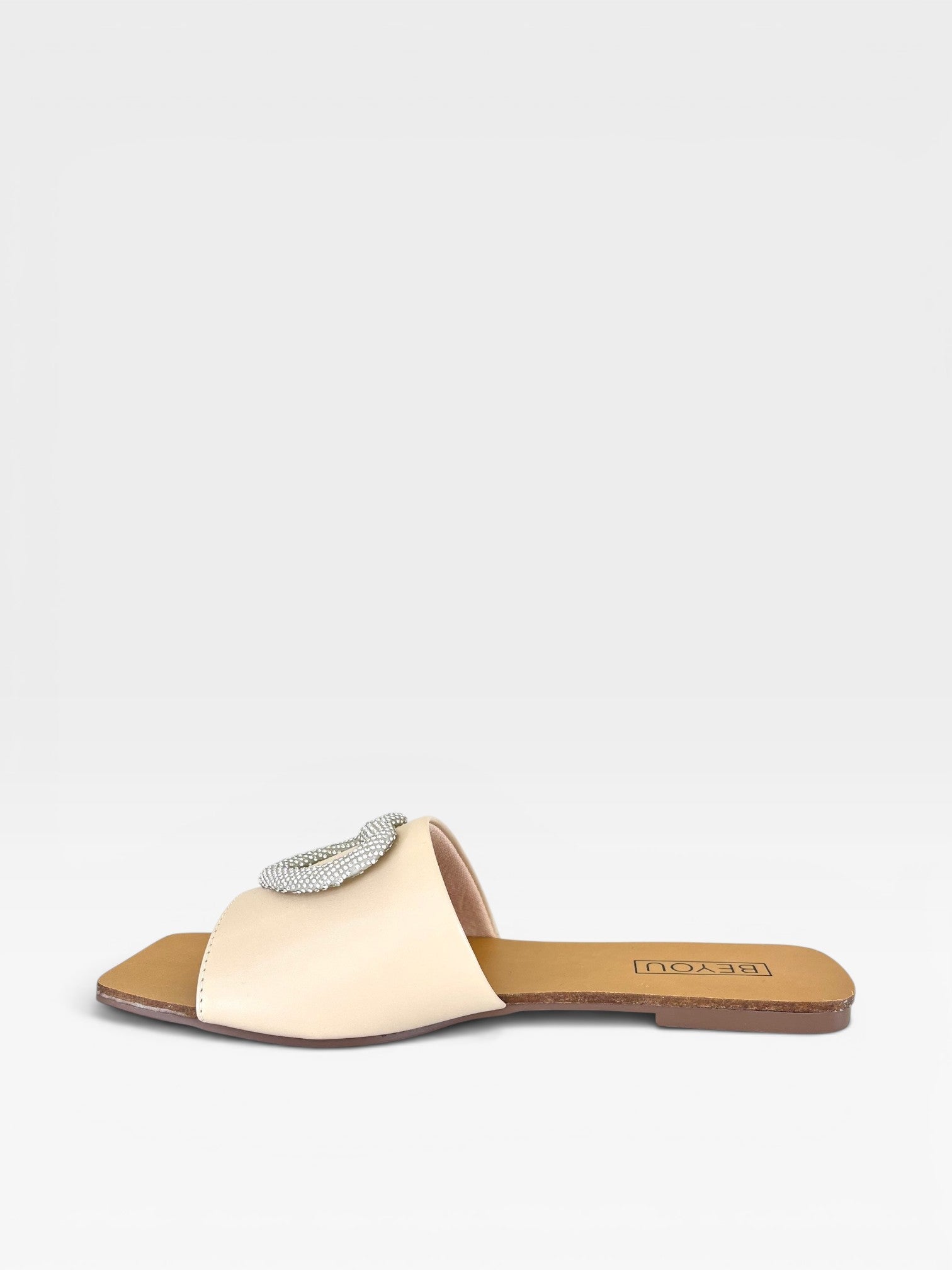 Rasteira Beyou Shoes Búzios nude em napa com detalhe de coração brilhante na parte superior, vista lateral.