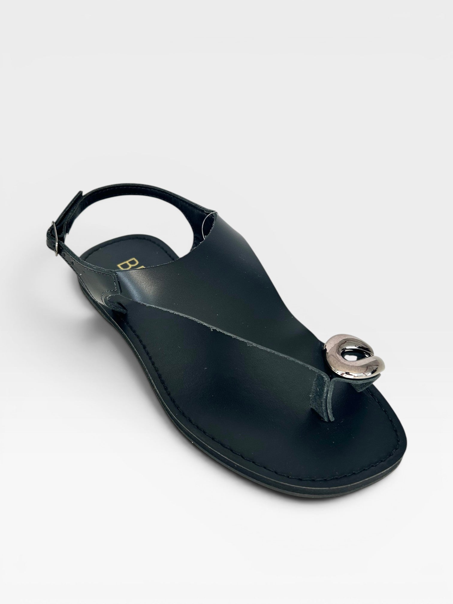 Rasteira Beyou Shoes Cancún preta em couro com detalhe metálico no dedo e ajuste traseiro