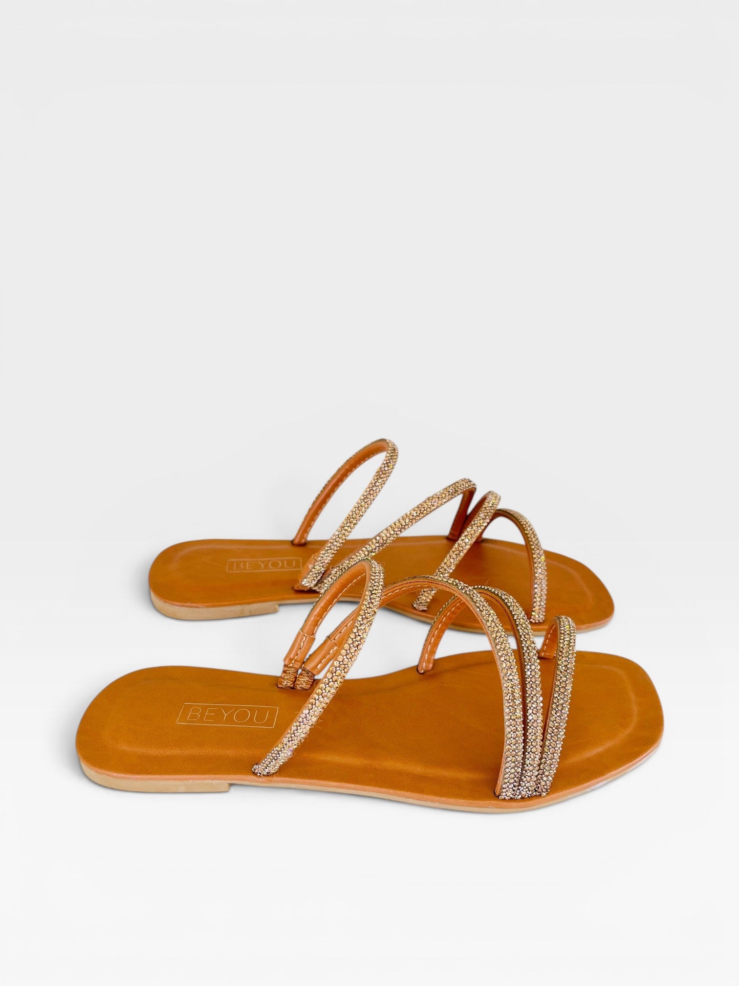 Rasteira Beyou Shoes caramelo em napa com tiras finas adornadas por pedrarias brilhantes e design elegante.