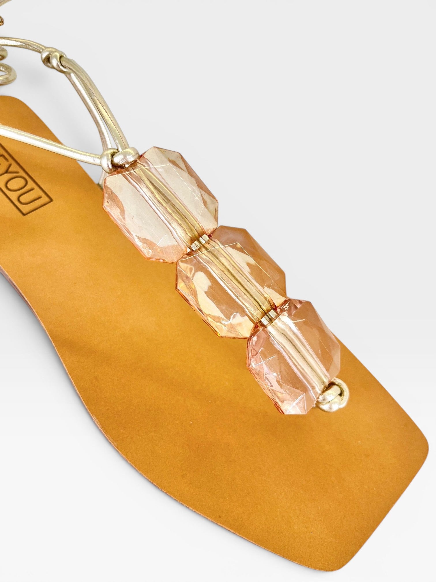 Rasteira Beyou Shoes caramelo em napa com tiras finas e detalhes em pedrarias transparentes sobre palmilha quadrada