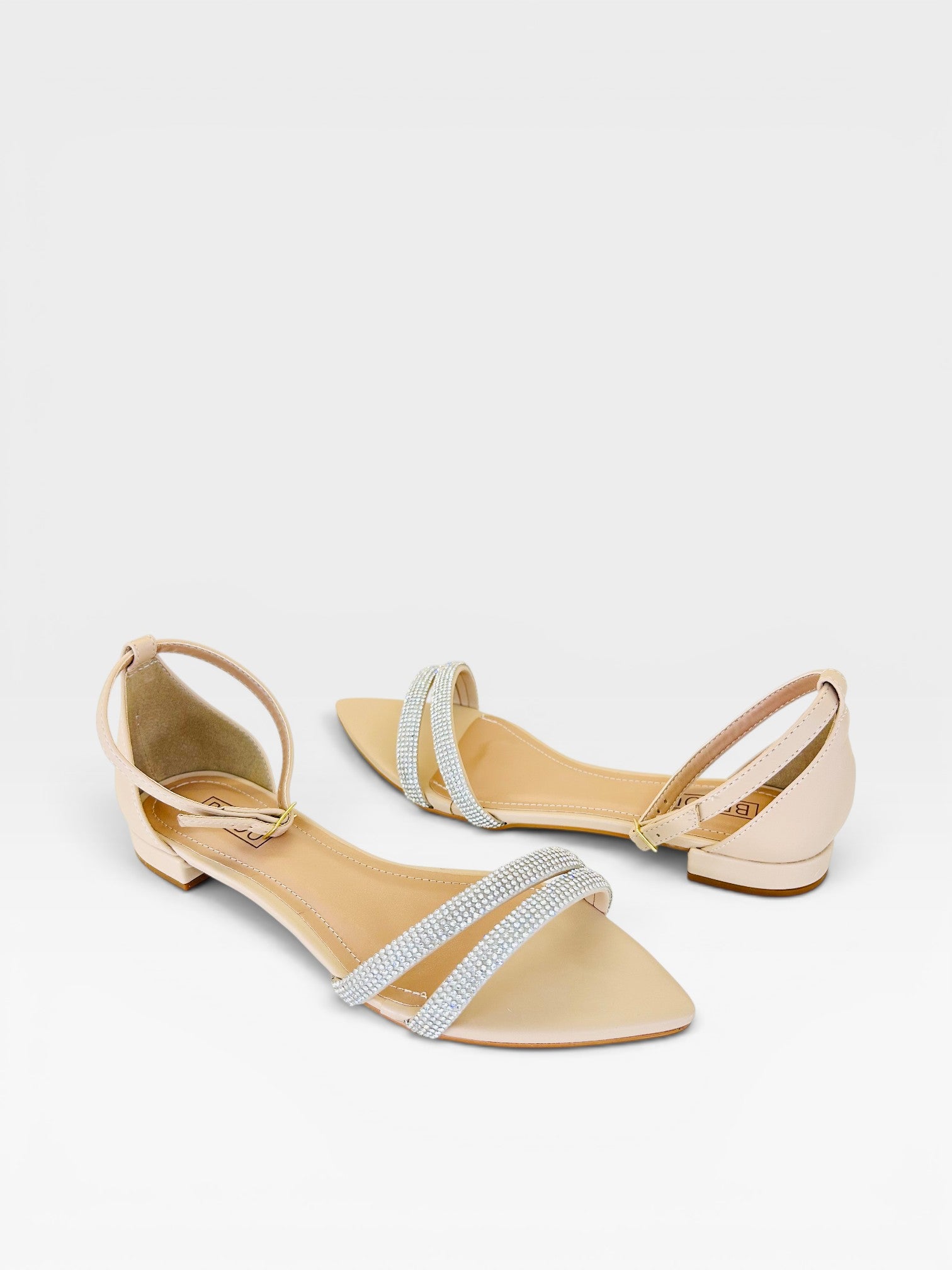 Rasteira Beyou Shoes Davos nude em napa com tiras finas decoradas com brilhos e fechamento por fivela no tornozelo