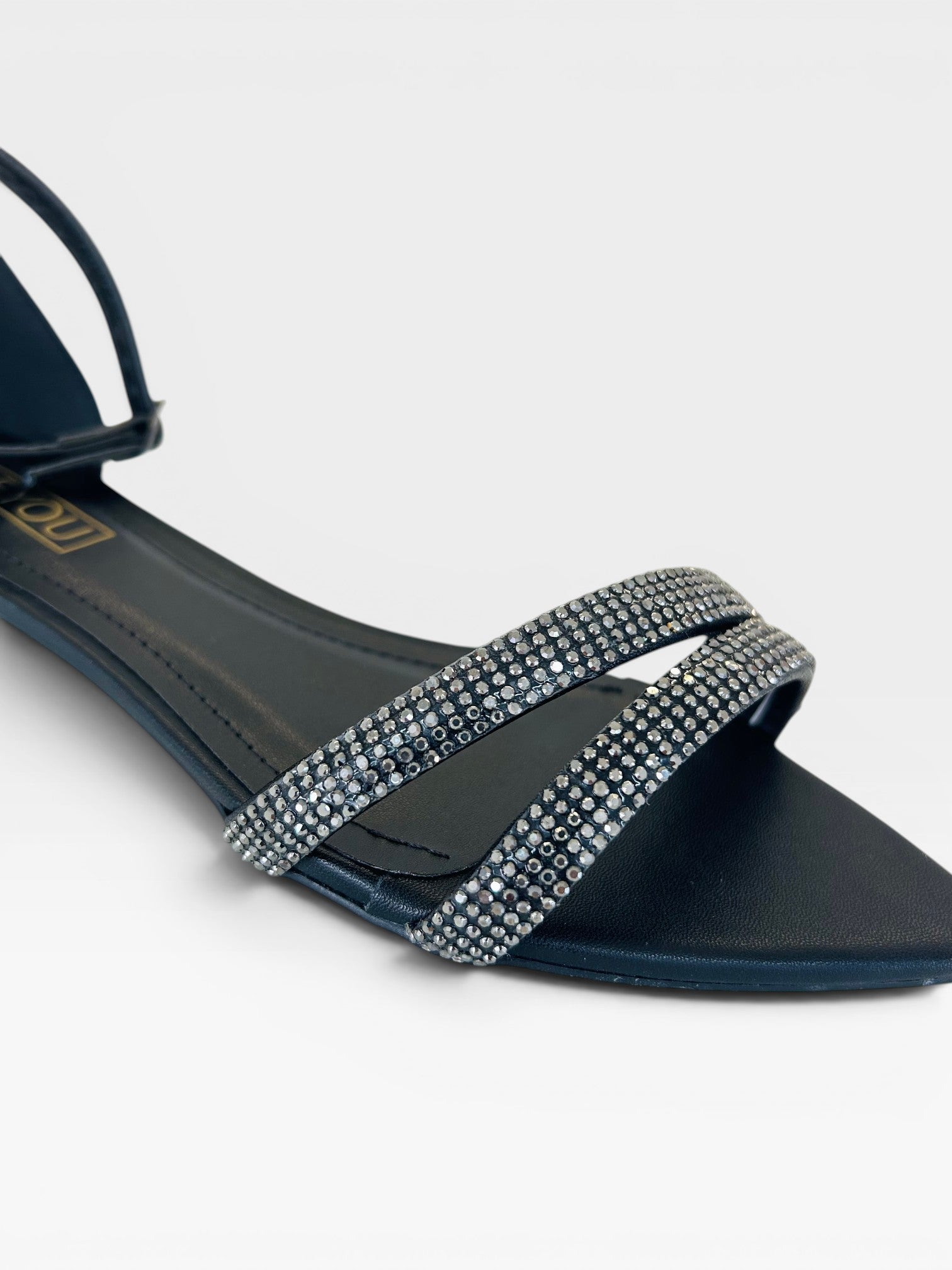 Rasteira Beyou Shoes Davos preta em napa com tiras finas decoradas com brilhos e fechamento no tornozelo