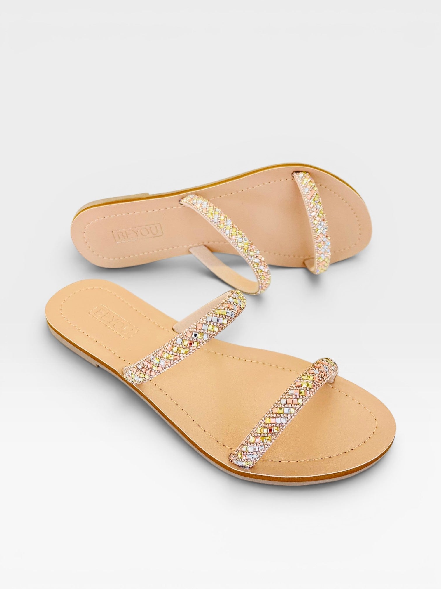 Rasteira Beyou Shoes Galícia na cor marfim, feita em napa com tiras decoradas por brilhos coloridos.