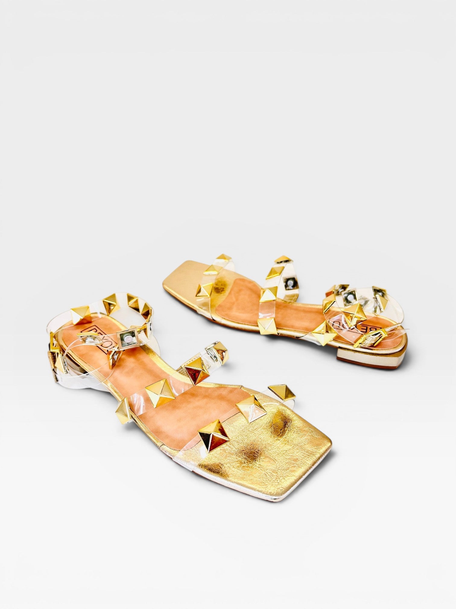 Rasteira Beyou Shoes Las Vegas ouro light com tiras de vinil transparente e aplicações de tachas douradas