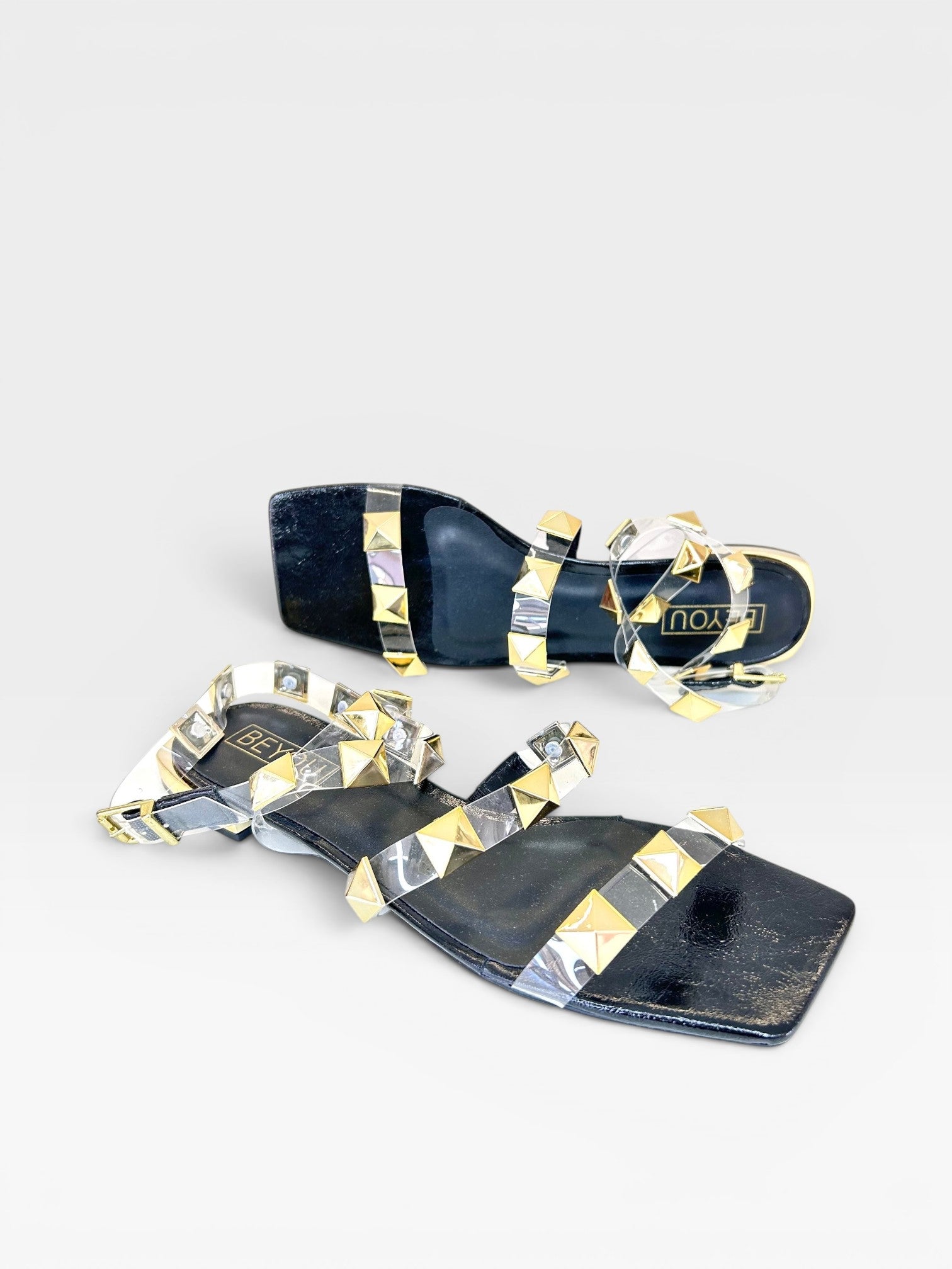 Rasteira Beyou Shoes Las Vegas preta com tiras de vinil transparente e aplicações de tachas douradas
