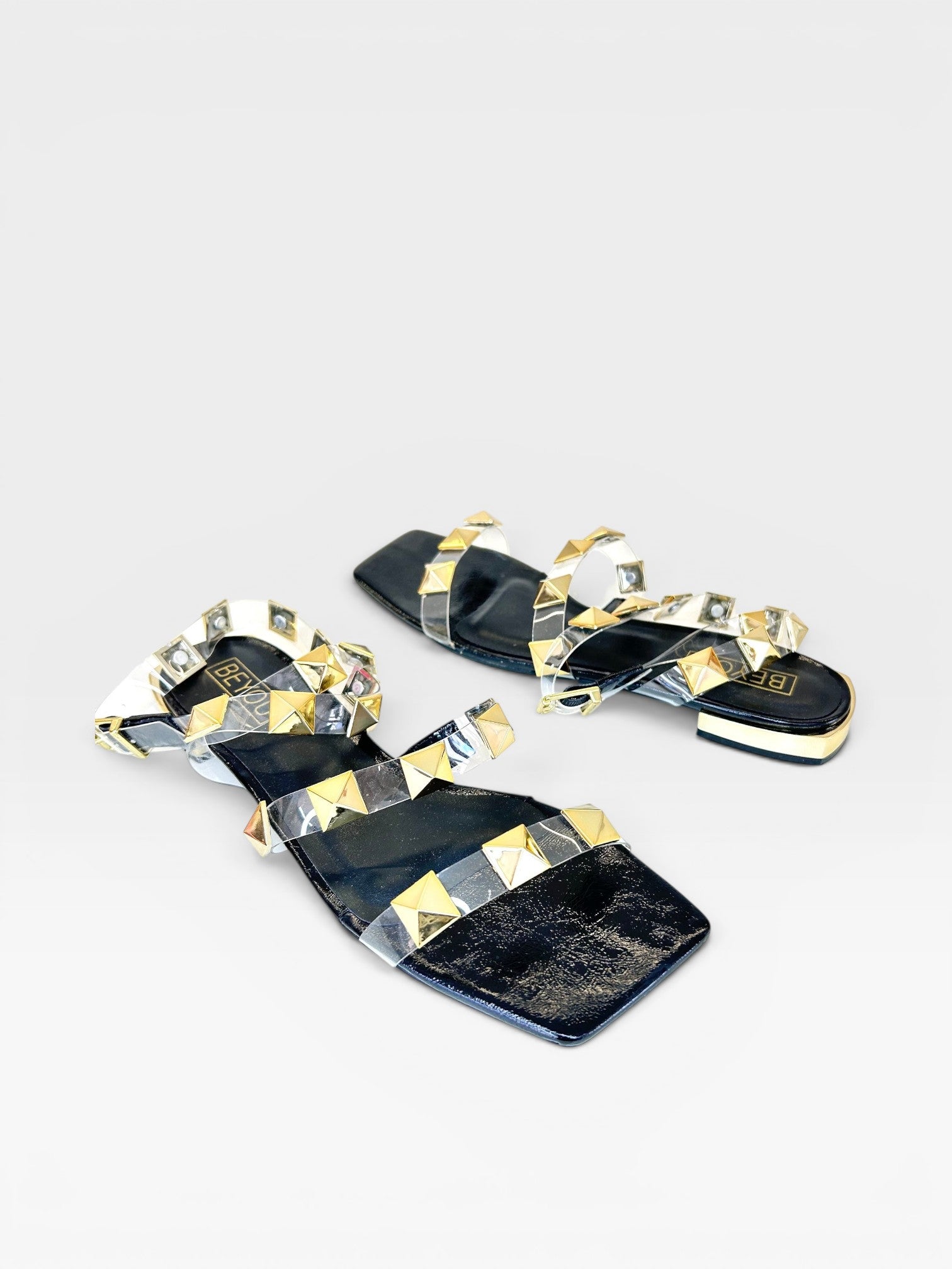 Rasteira Beyou Shoes Las Vegas preta com tiras de vinil transparente e aplicações de tachas douradas