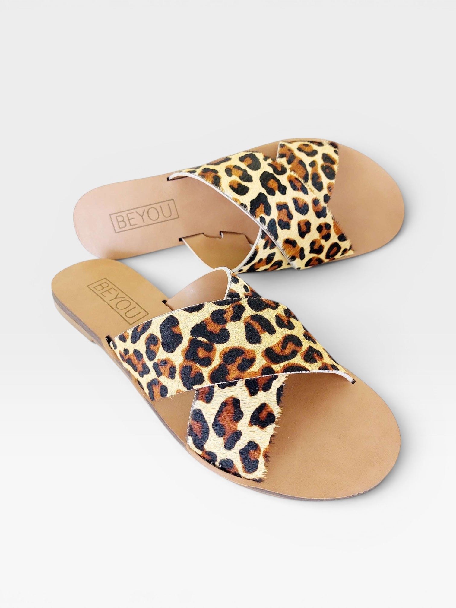 Rasteira Beyou Shoes Marrakech em couro com estampa animal print de onça e tiras cruzadas sobre palmilha bege