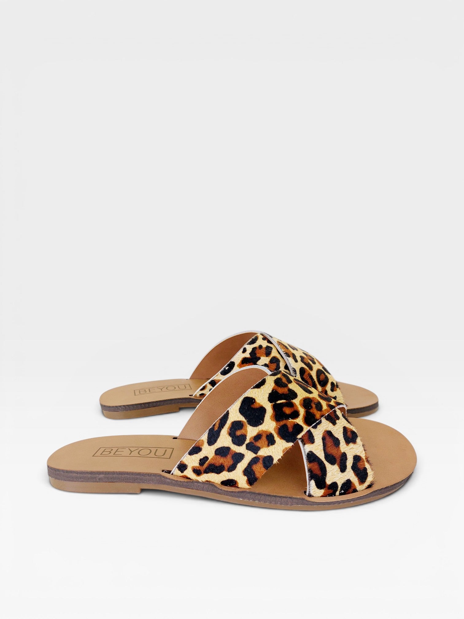 Rasteira Beyou Shoes Marrakech em couro com estampa animal print de onça e design de tiras cruzadas.