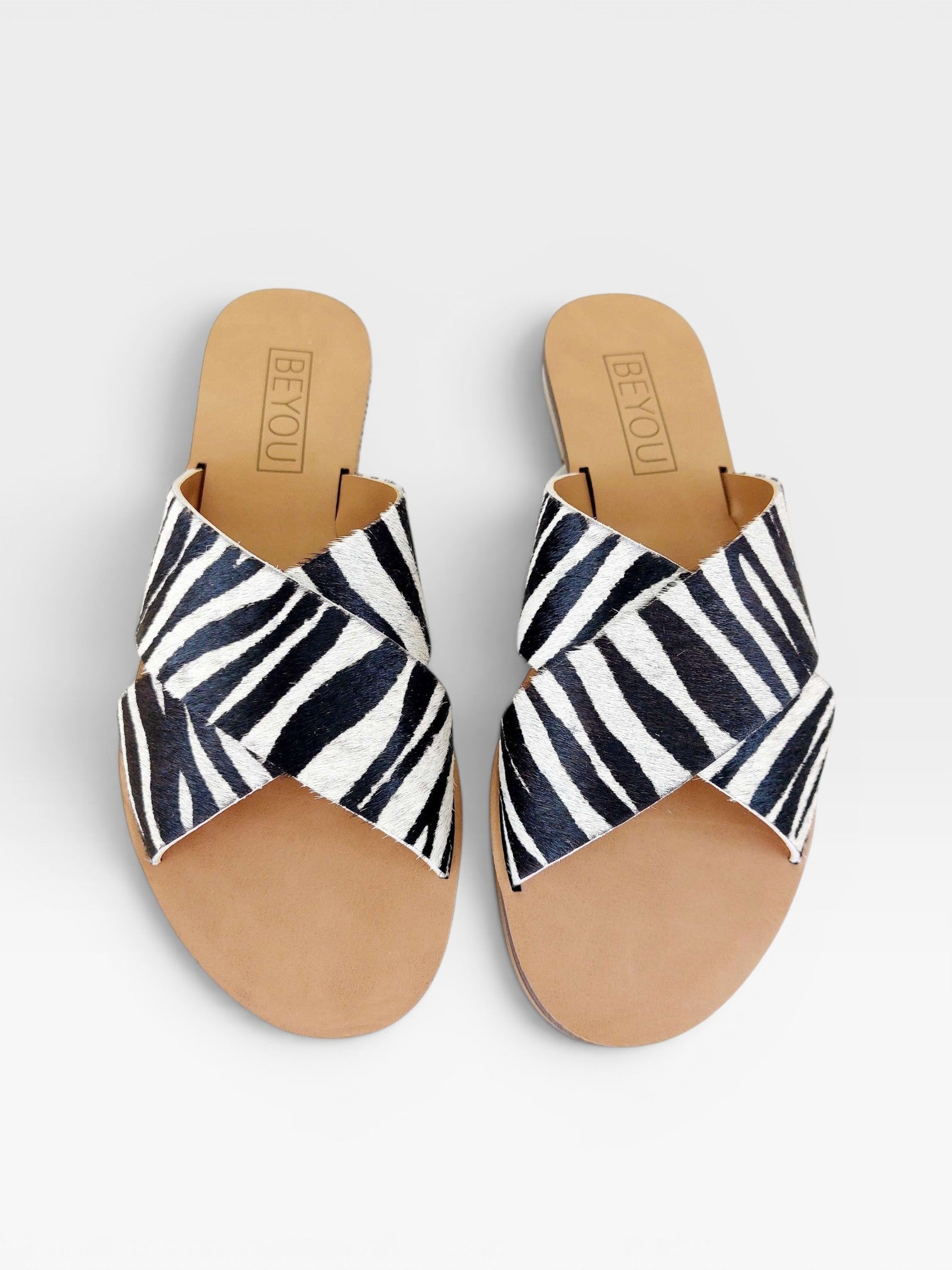 Rasteira Beyou Shoes Marrakech em couro com estampa animal print de zebra e tiras cruzadas sobre o peito do pé