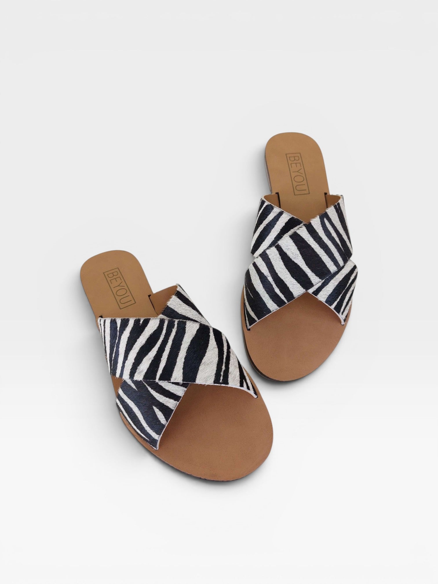 Rasteira Beyou Shoes Marrakech em couro com estampa animal print de zebra e tiras cruzadas sobre o peito do pé.