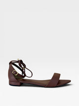 Rasteira Beyou Shoes Merano marrom em napa com tiras de amarração no tornozelo e fivela dourada, vista lateral.