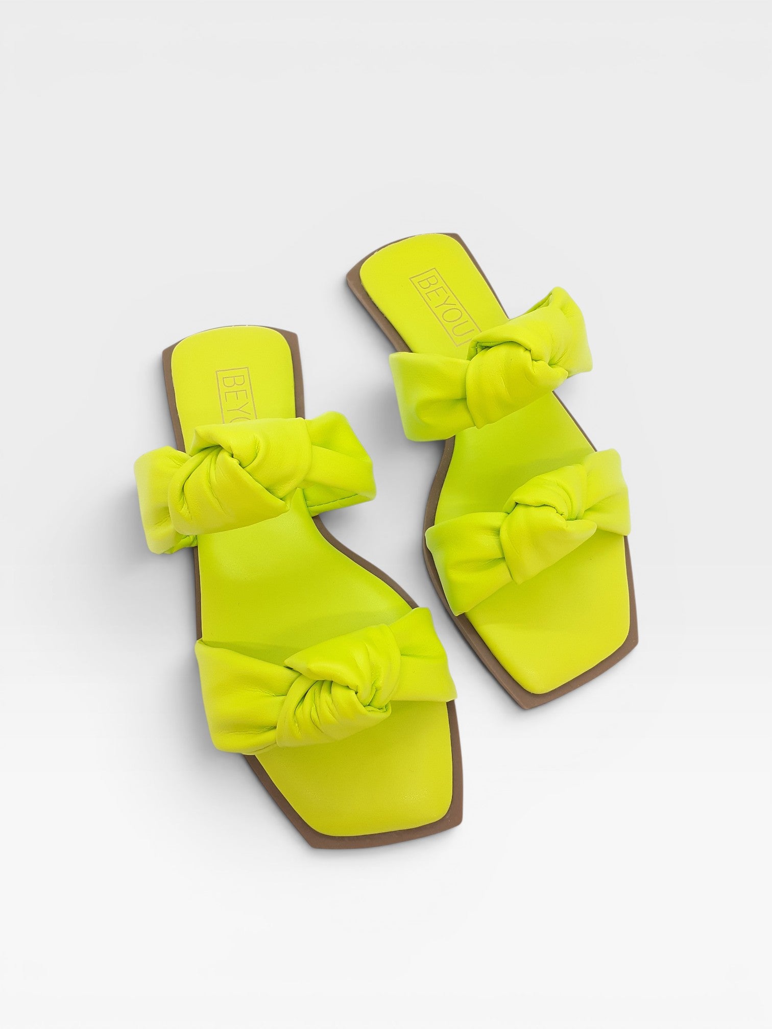 Rasteira Beyou Shoes Miami na cor limão siciliano, feita em napa com tiras de nós e bico quadrado.