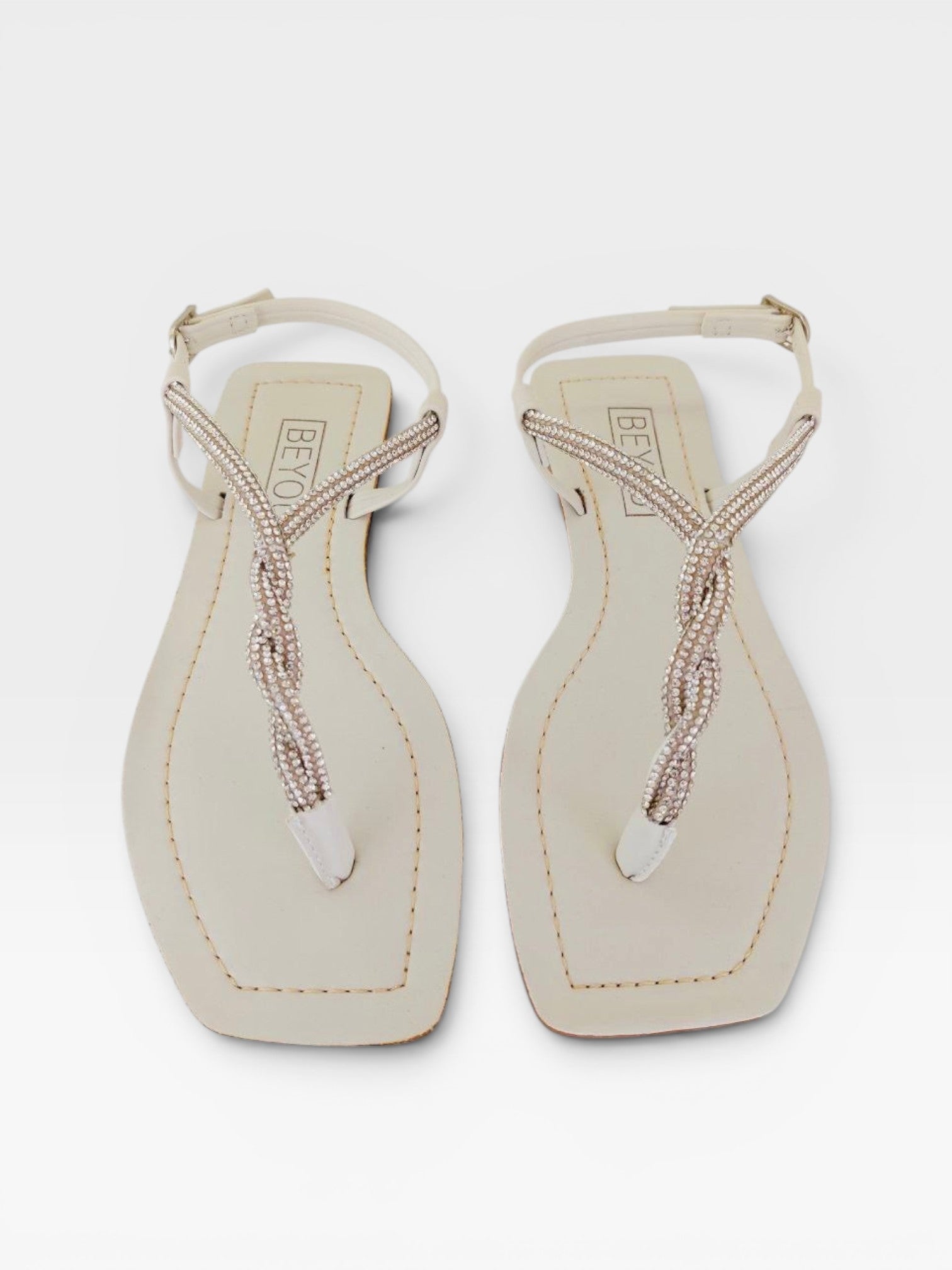 Rasteira Beyou Shoes Noronha off white em napa com tiras finas trançadas e detalhes em pedrarias brilhantes