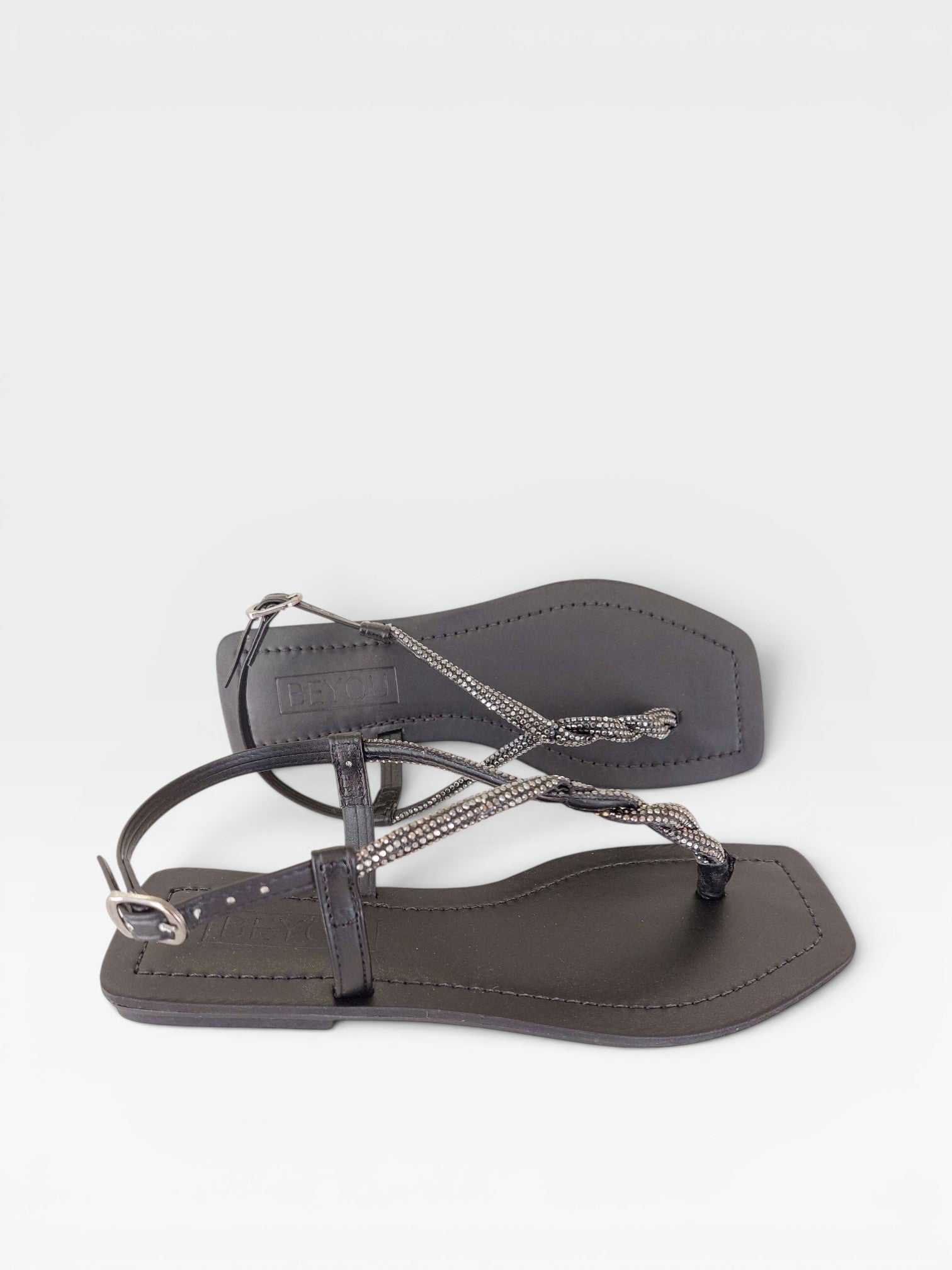 Rasteira Beyou Shoes Noronha preta em napa com tiras finas adornadas por brilho e fechamento lateral