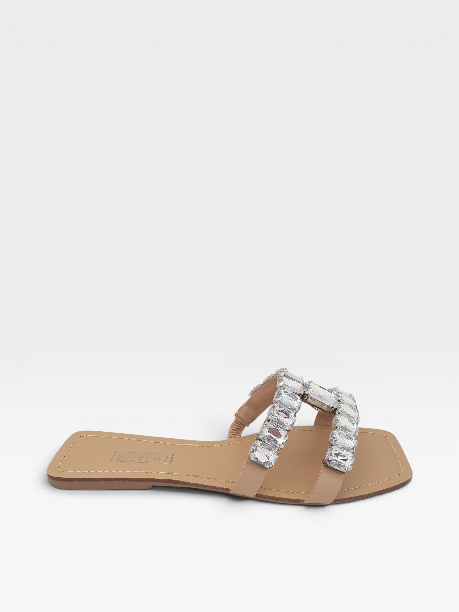 Rasteira Beyou Shoes nude em napa com tiras adornadas por pedrarias brilhantes e bico quadrado