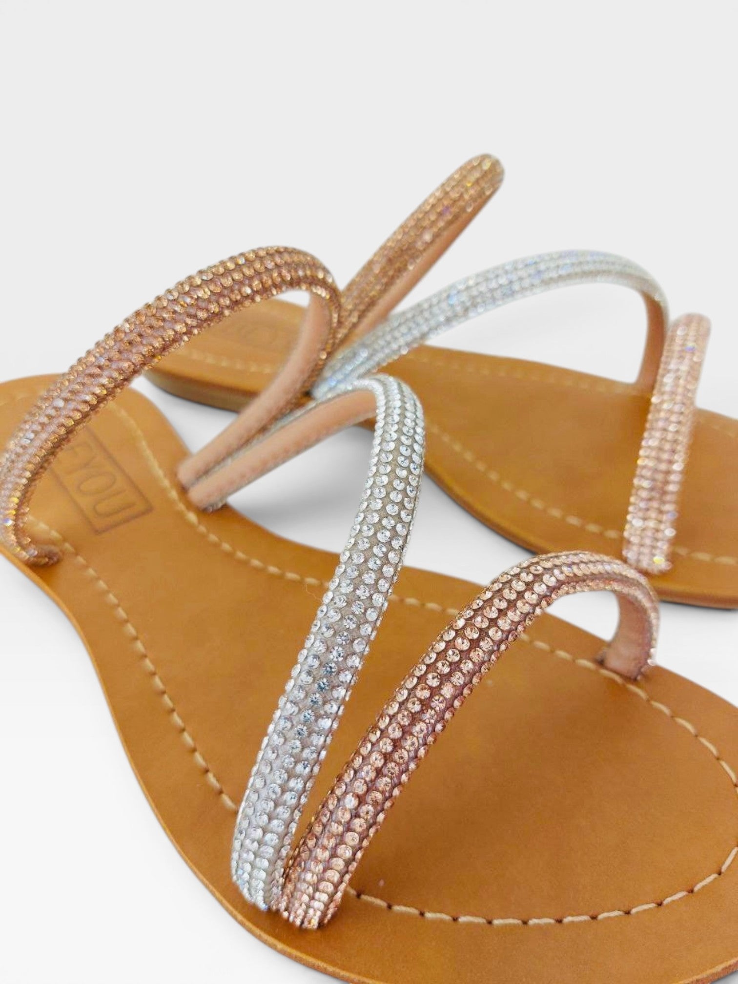 Rasteira Beyou Shoes nude em napa com tiras delicadas adornadas por pedrarias brilhantes em tons de prata e rosê
