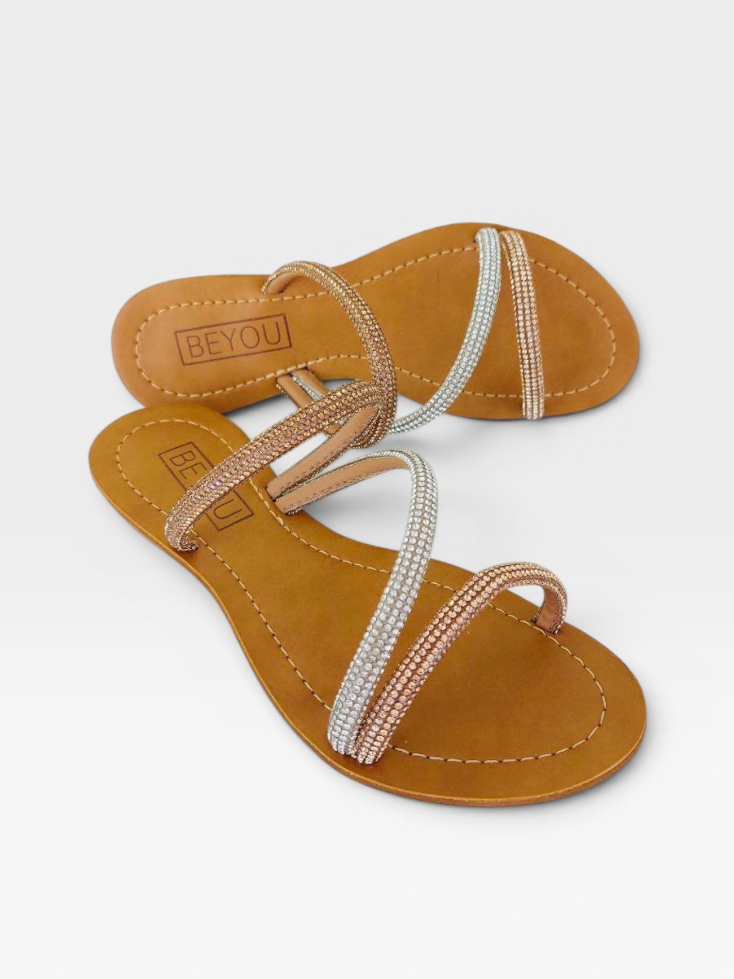 Rasteira Beyou Shoes nude em napa com tiras delicadas adornadas por pedrarias brilhantes em tons de dourado e prata