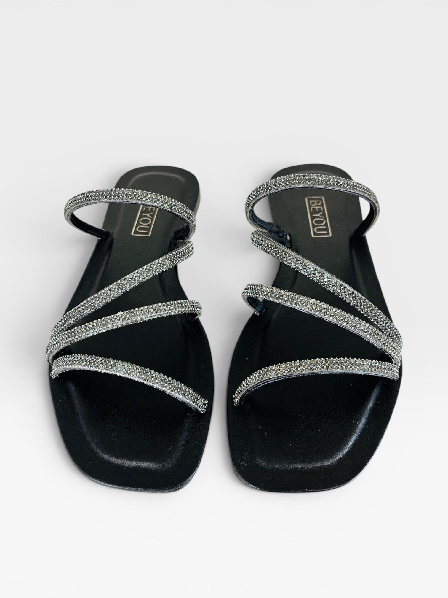 Rasteira Beyou Shoes preta em napa com tiras finas adornadas por pedrarias brilhantes e design elegante.