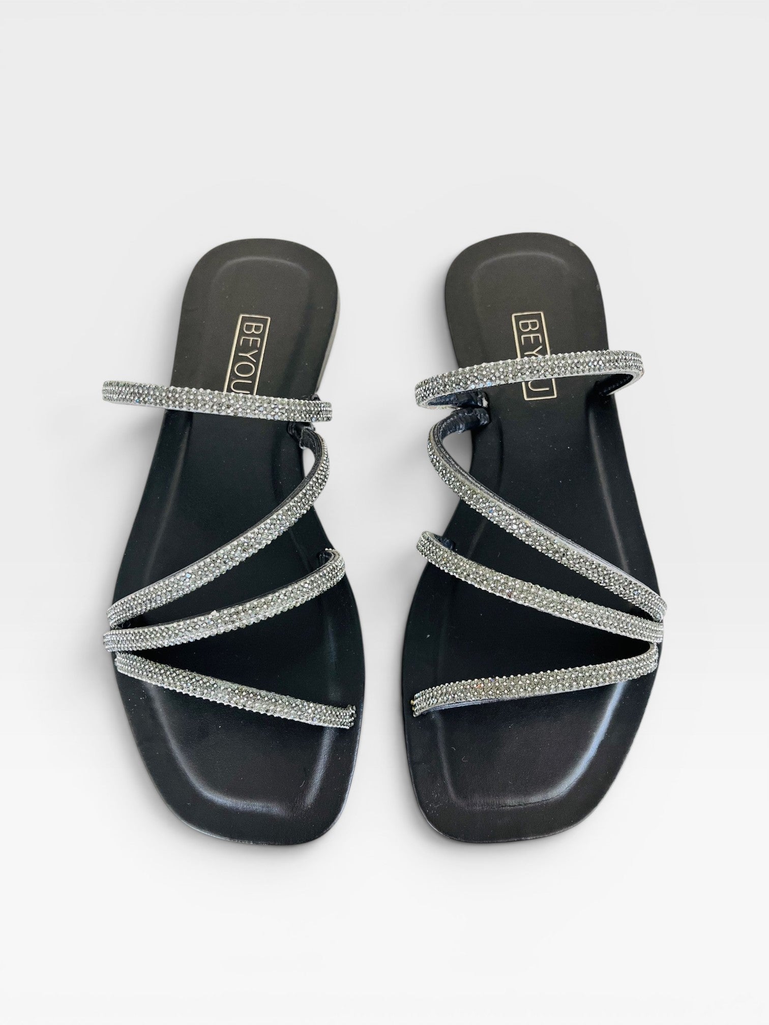 Rasteira Beyou Shoes preta em napa com tiras finas adornadas por pedrarias brilhantes e design elegante