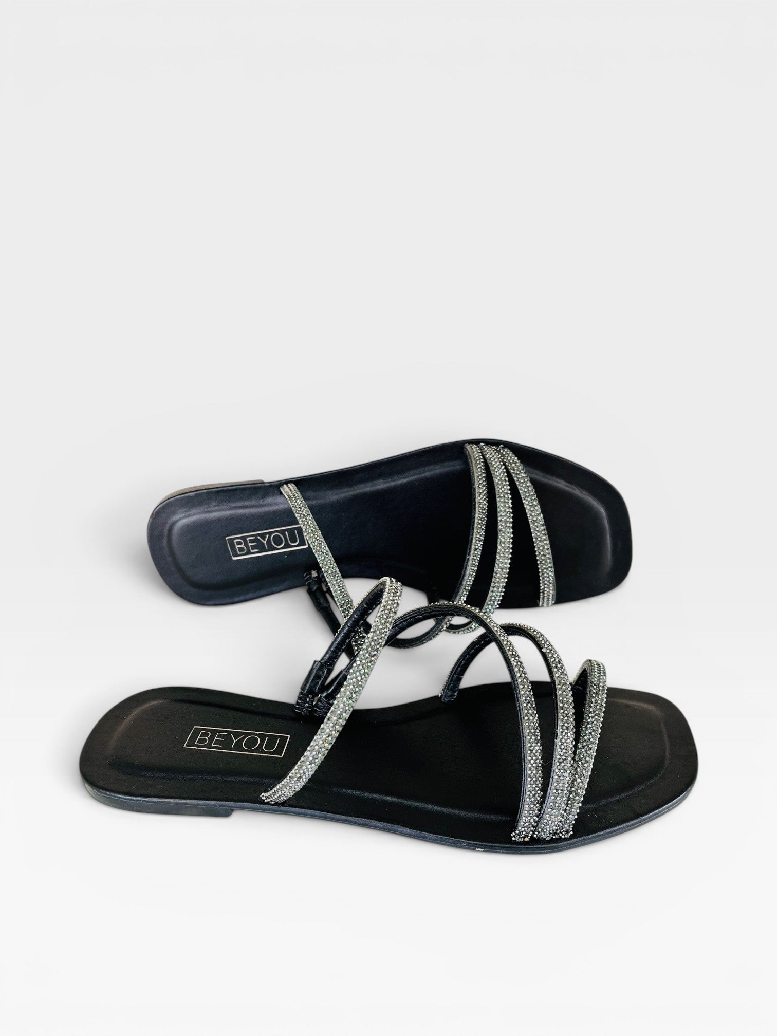 Rasteira Beyou Shoes preta em napa com tiras finas adornadas por pedrarias brilhantes e design elegante