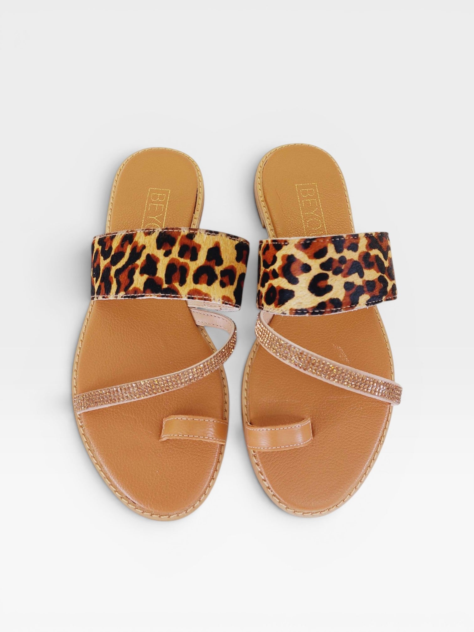 Rasteira Beyou Shoes Riad em couro com estampa de onça, tiras com pedrarias e detalhe de dedo