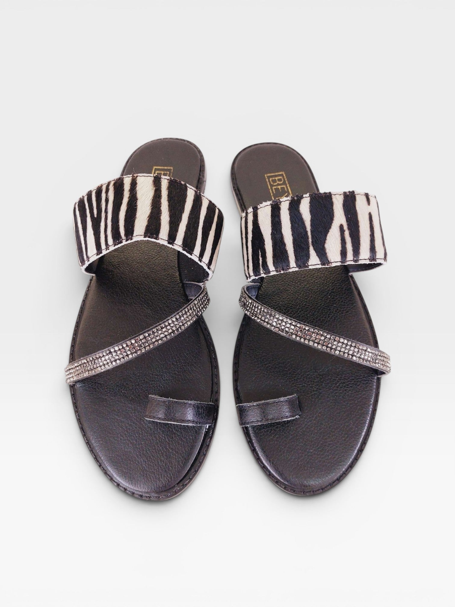 Rasteira Beyou Shoes Riad em couro com estampa de zebra e tiras decoradas com pedrarias brilhantes